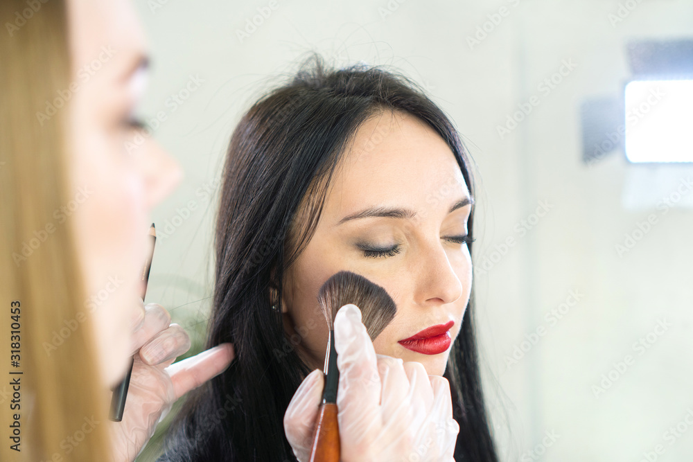 Makeup artist doing make up for beautiful brunette woman Makeup artist doing make up for beautiful brunette woman