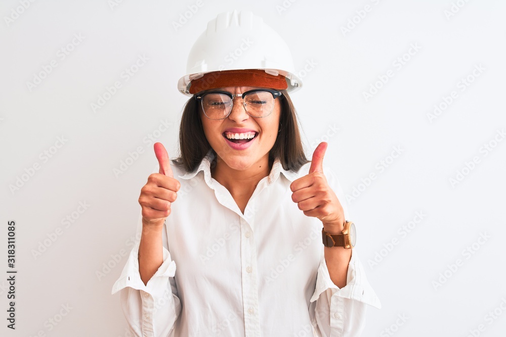 Young beautiful architect woman wearing helmet and glasses over isolated white background excited for success with arms raised and eyes closed celebrating victory smiling. Winner concept.