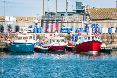 Row of colourful fishing boats in a harbour on a sunny spring day photo