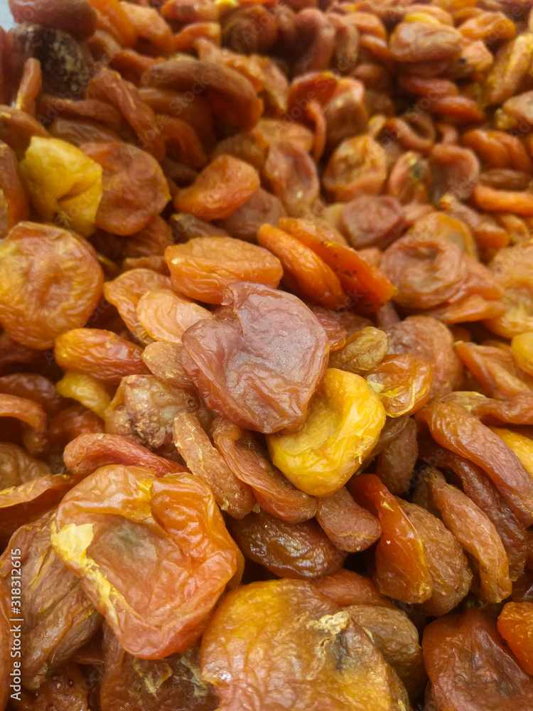 a mixture of large and small dried apricots on a supermarket counter a mixture of large and small dried apricots on a supermarket counter