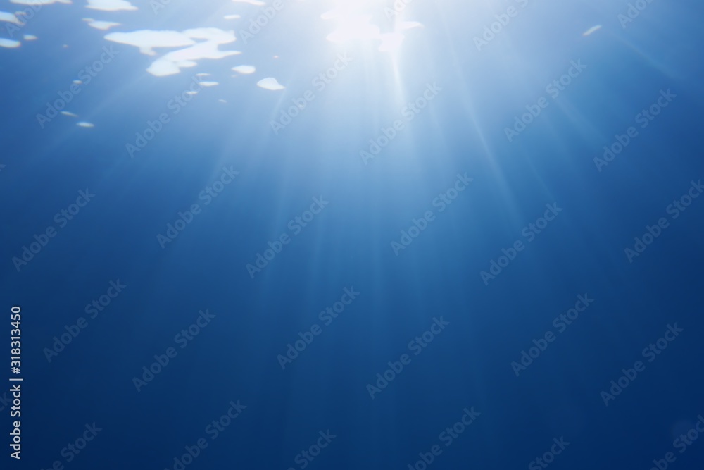 Sun beams shinning underwater . Trendy color classic blue background.