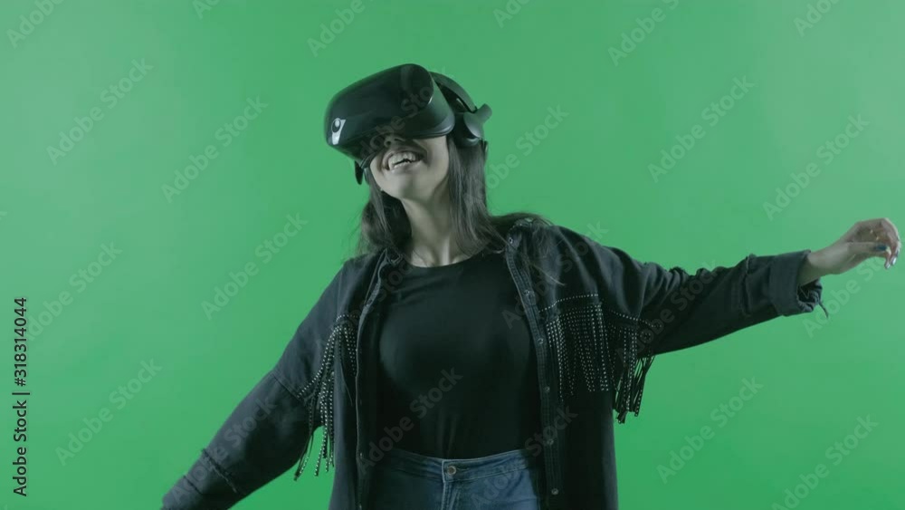 Happy young beautiful woman dancing in the VR headset. Virtual reality helmet on the green background. Chroma Key Happy young beautiful woman dancing in the VR headset. Virtual reality helmet on the green background. Chroma Key