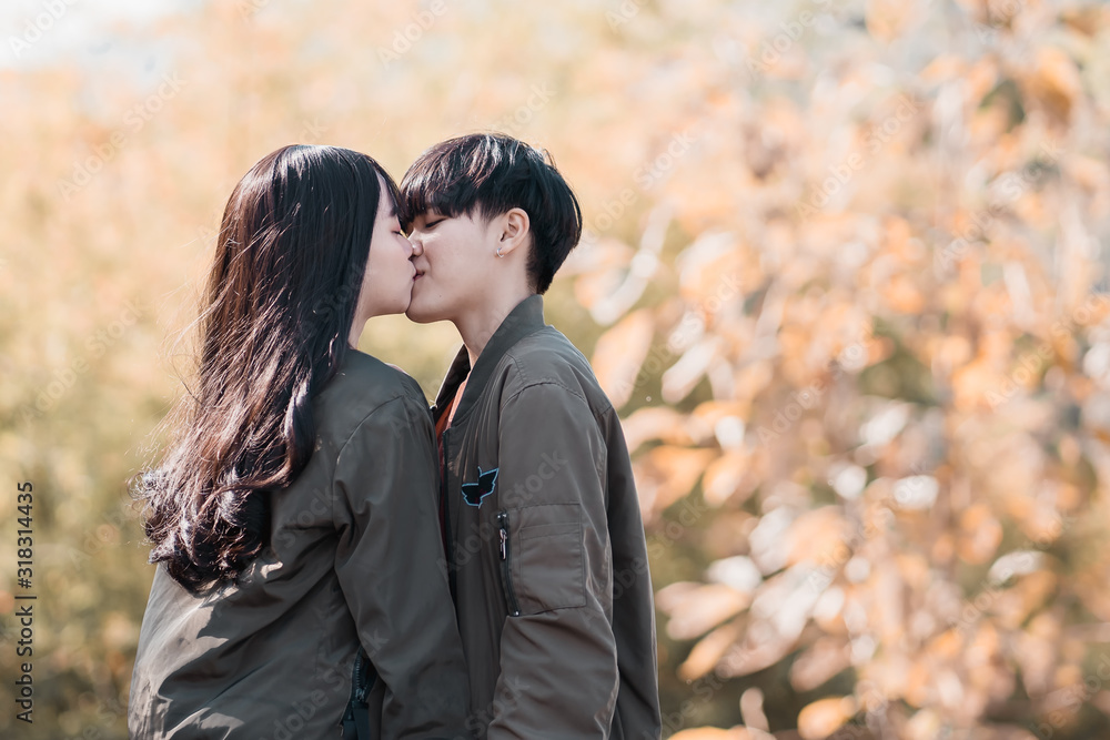 A couple of LGBT Lesbian holding hands each other while smiling and kissing. A couple of LGBT Lesbian holding hands each other while smiling and kissing.