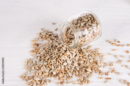 sunflower seeds in a jar  on white wooden background. vegetarian food, eco food concepts
