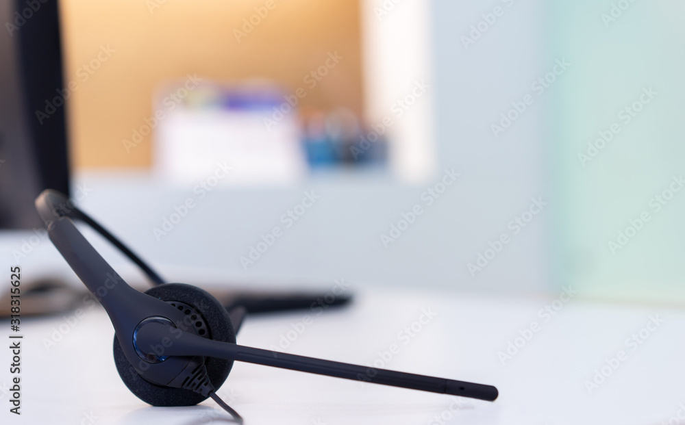 close up headset of call center and VOIP for communication technology on desktop pc computer table at the operational monitoring office room for telecommunication network center concept close up headset of call center and VOIP for communication technology on desktop pc computer table at the operational monitoring office room for telecommunication network center concept