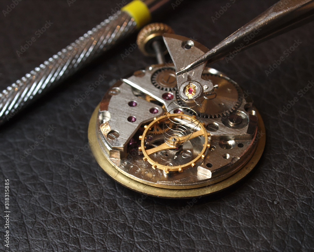 watchmaker repairing old watch mechanism