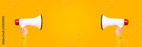 megaphones in hands on a yellow background, panoramic mock-up image with space for text, attention concept announcement