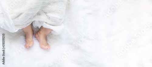 Cute newborn baby girl in white blanket on nursery bed. Adorable new born child, little boy eyes look people Family, new childhood, infant soft skin portrait concept. Jaundice syndrome life hospital. photo