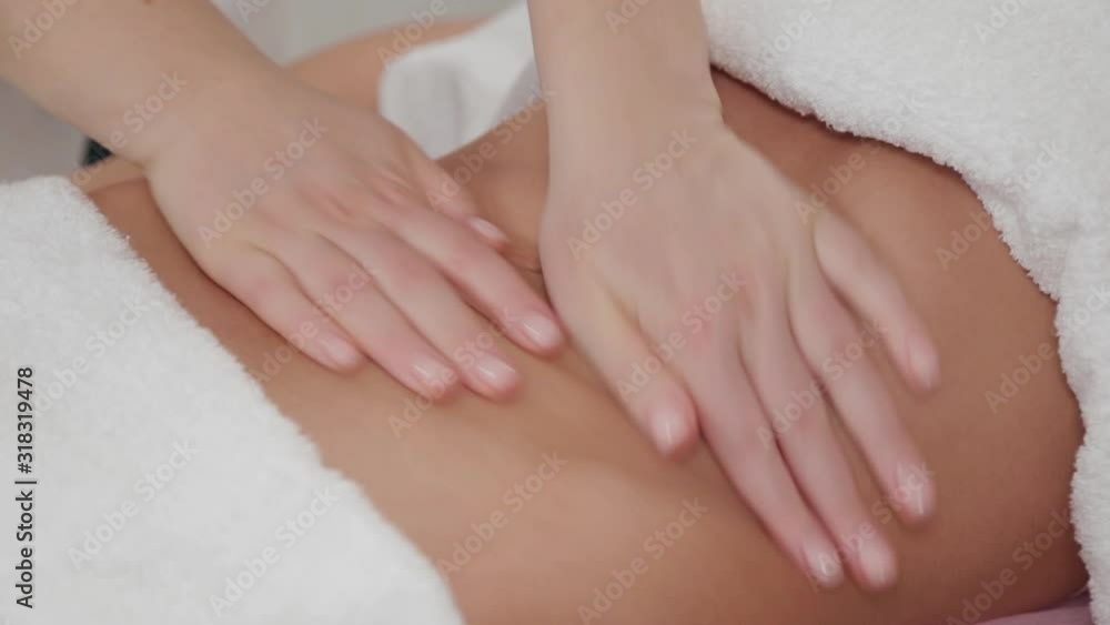Woman massage therapist does massage on the stomach of a young girl. Woman massage therapist does massage on the stomach of a young girl.
