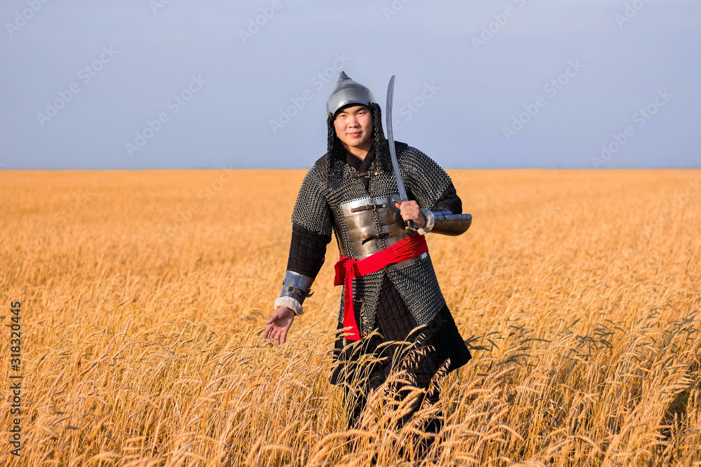 A nomad warrior in oriental armor with a saber and a helmet from the 16th and 18th centuries stands knee-deep in a wheat field.