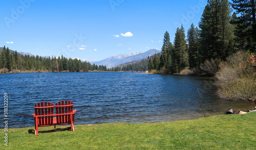 Landscape of red chair by Hume Lake with view of forest and mountains at Kings Canyon National Park in California