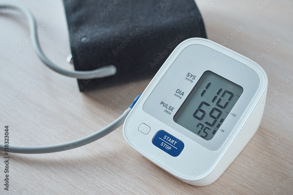 Digital blood pressure monitor on the table, closeup. Helathcare and medical concept Digital blood pressure monitor on the table, closeup. Helathcare and medical concept