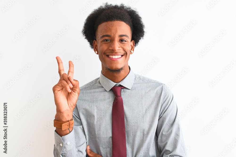 Young african american businessman wearing tie standing over isolated white background smiling with happy face winking at the camera doing victory sign. Number two. Young african american businessman wearing tie standing over isolated white background smiling with happy face winking at the camera doing victory sign. Number two.