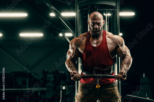 Bodybuilder strong man pumping up biceps muscles