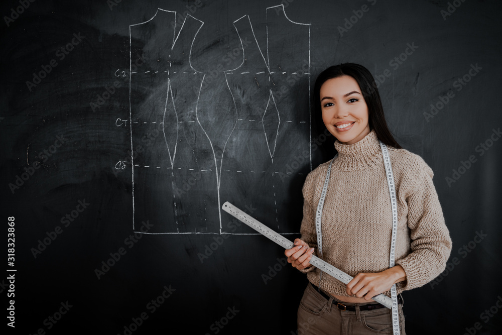 Beautiful educated seamstress of the highest qualification conducts a