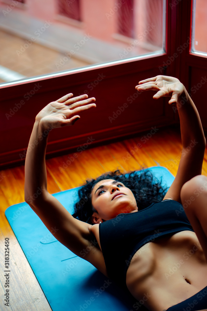 Fototapeta premium Latin woman performing hypopressive yoga exercises