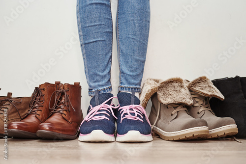 Woman chooses comfortable brown leather shoes among bunch of the different pairs photo