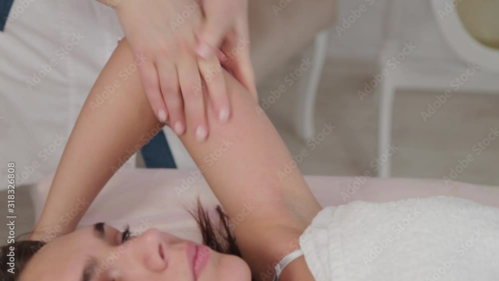 Woman massage therapist doing massage on the arm of a young girl. Woman massage therapist doing massage on the arm of a young girl.