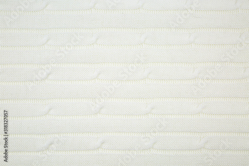 Background of knitted fabric openwork pattern in white. Backgrounds and structures.
