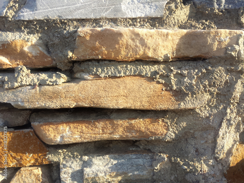 Gray and orange stone wall background texture with sun light reflection Gray and orange stone wall background texture with sun light reflection