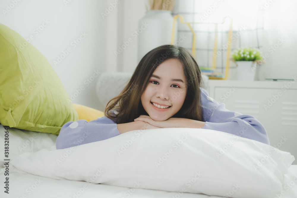 portrait happy young asian pretty woman in casual clothing smiling and lying on bed and looking at camera at morning in bedroom at home, lifestyle, good morning, holiday and joyful weekend concept portrait happy young asian pretty woman in casual clothing smiling and lying on bed and looking at camera at morning in bedroom at home, lifestyle, good morning, holiday and joyful weekend concept
