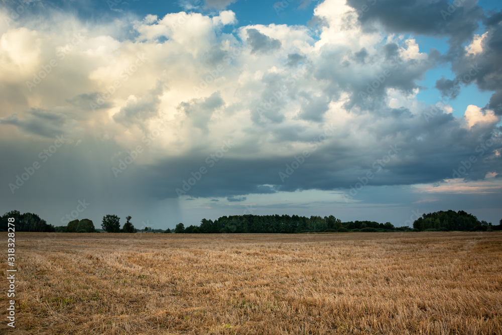 Cloud with rain over stubble field in Nowiny, Poland Cloud with rain over stubble field in Nowiny, Poland