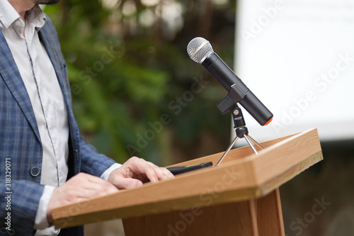 Картината върху платно A man stands a with a microphone and holds a conference
