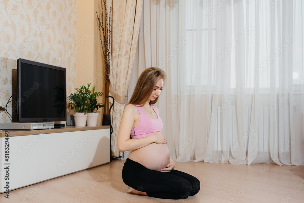 A pregnant girl does yoga at home. Health A pregnant girl does yoga at home. Health