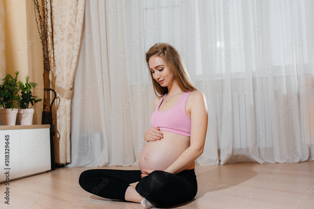 A pregnant girl does yoga at home. Health A pregnant girl does yoga at home. Health