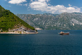 Bay of Kotor, also known as Kotorska Boka, during a quiet summer afternoon with mountains reflecting in the waters of the Adriatic sea.