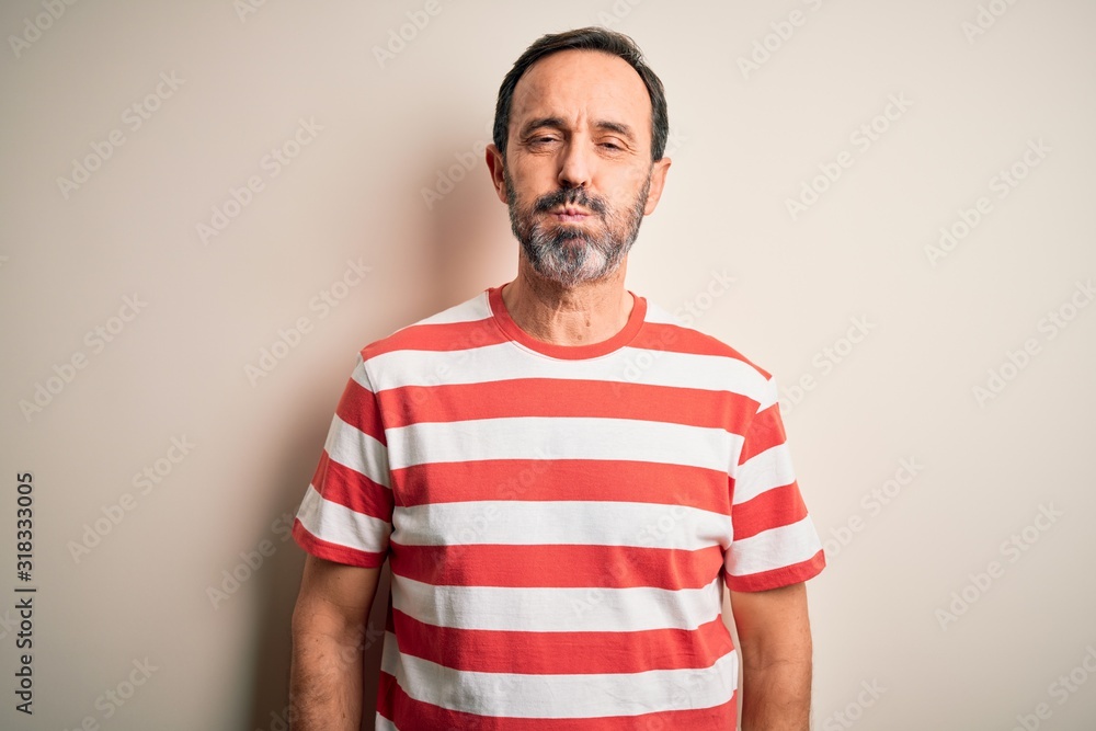 Middle age hoary man wearing casual striped t-shirt standing over isolated white background puffing cheeks with funny face. Mouth inflated with air, crazy expression. Middle age hoary man wearing casual striped t-shirt standing over isolated white background puffing cheeks with funny face. Mouth inflated with air, crazy expression.