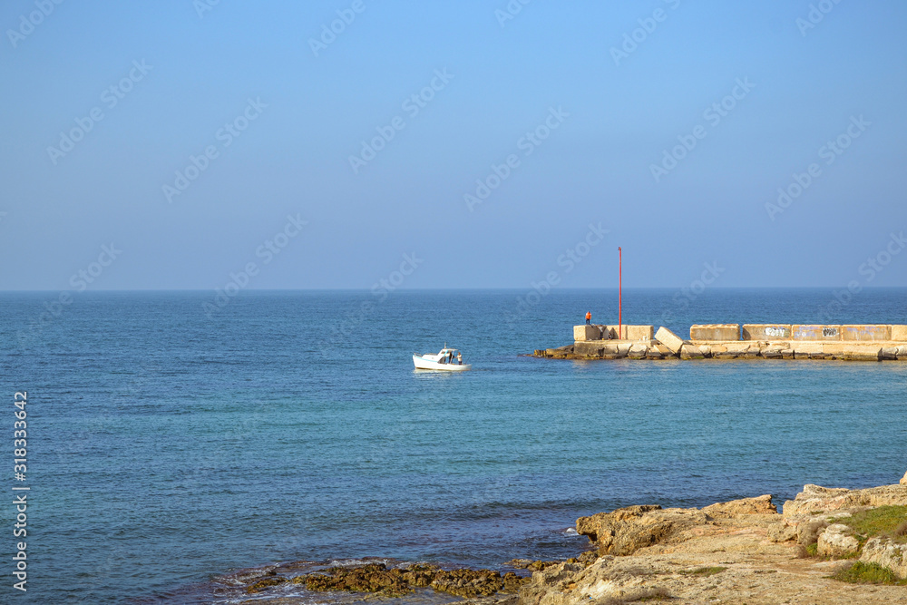 Molo del porto sul mare mediterraneo e piccola barca