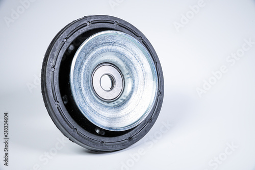New thrust bearing of front suspension strut of a car on a gray background. The concept of new spare parts and replacement parts in service centers