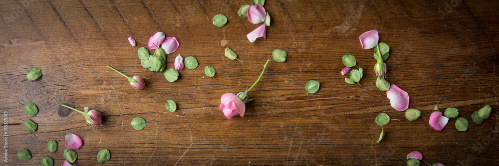 Border on a distressed pine table with tiny buds, flower petals and leaves create the perfect background for valentines day or mothers day Border on a distressed pine table with tiny buds, flower petals and leaves create the perfect background for valentines day or mothers day