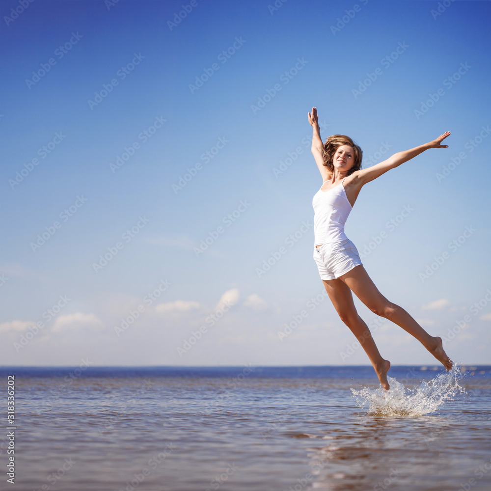Woman enjoys on beach. Girl jumps on waves and laughs. Model in swimsuit on ocean vacation. Tourism and rest Woman enjoys on beach. Girl jumps on waves and laughs. Model in swimsuit on ocean vacation. Tourism and rest