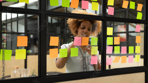 African American female employee develop plan on sticky notes photo