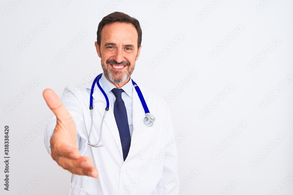 Middle age doctor man wearing coat and stethoscope standing over isolated white background smiling friendly offering handshake as greeting and welcoming. Successful business. Middle age doctor man wearing coat and stethoscope standing over isolated white background smiling friendly offering handshake as greeting and welcoming. Successful business.