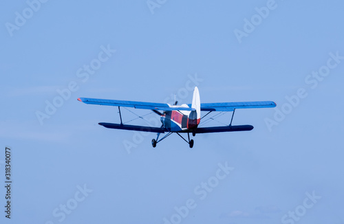 Vintage soviet and russian biplane. Veteran of avia. Aircraft of agricultural aviation. Transport for skydivers in blue sky.