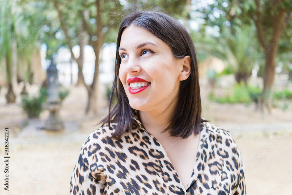 Young beautiful woman with red lips smiling happy at garden Young beautiful woman with red lips smiling happy at garden