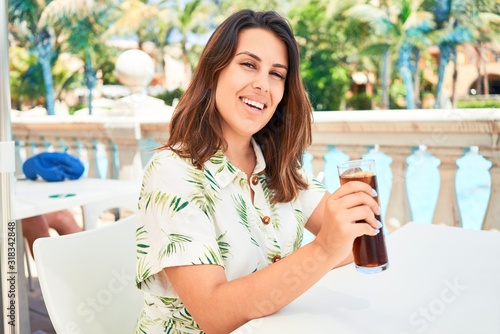 Beutiful woman sitting at bar pool on hotel resort drinking fresh soda enyojing summer vacation photo