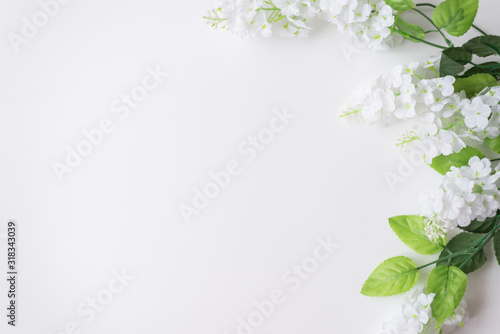 Spring and summer background. White flowers with greenery on a white background. Space for text © Марина Шавловская
