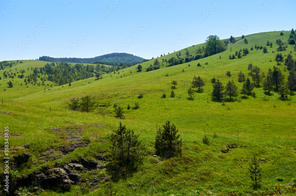 Idyllic mountain landscape - with hills, pastures, fields and valleys - in spring