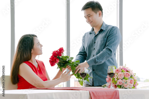 Man giving red rose bouquet with woman