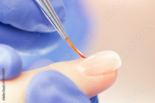 Macro photo of thin brush for manicure nails girl