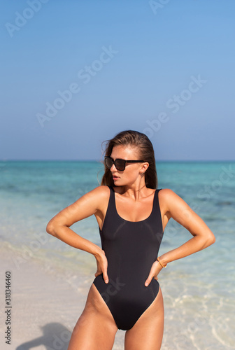 Sexy beautiful girl in a black swimsuit on the islands in the ocean.