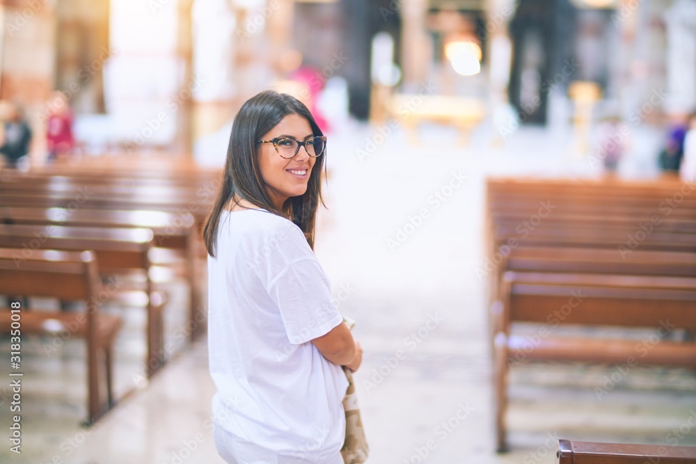 Fototapeta premium Young beautiful woman smiling happy and confident. Standing with smile on face at church
