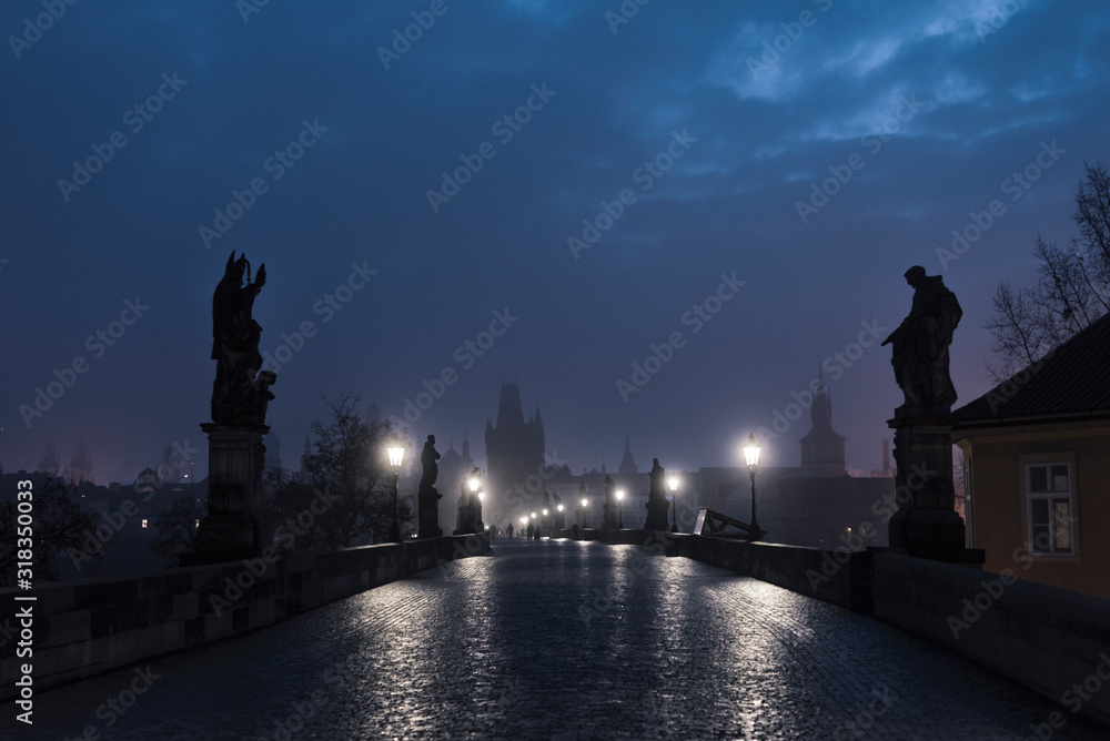 Obraz premium Female tourist walking alone on the Charles Bridge during the early morning in Prague, capital of Czech Republic
