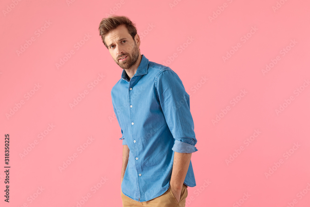 happy young man in denim shirt holding hands in pockets happy young man in denim shirt holding hands in pockets