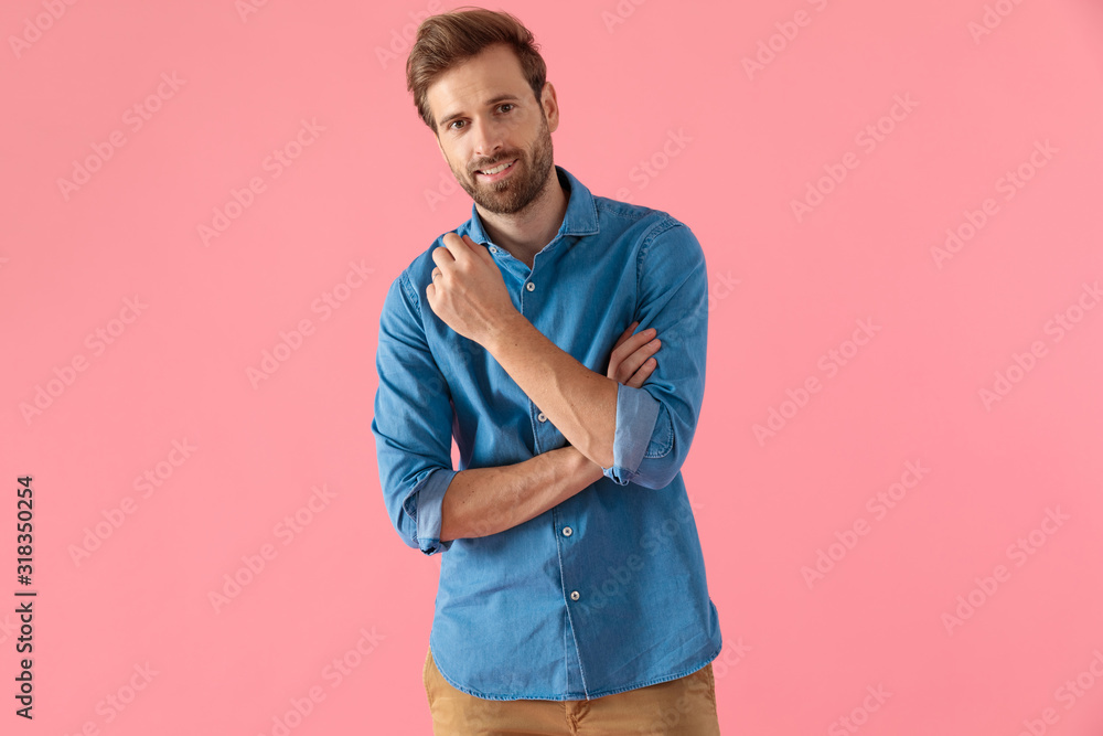 Fototapeta premium happy casual man holding elbow in fashion pose and smiling