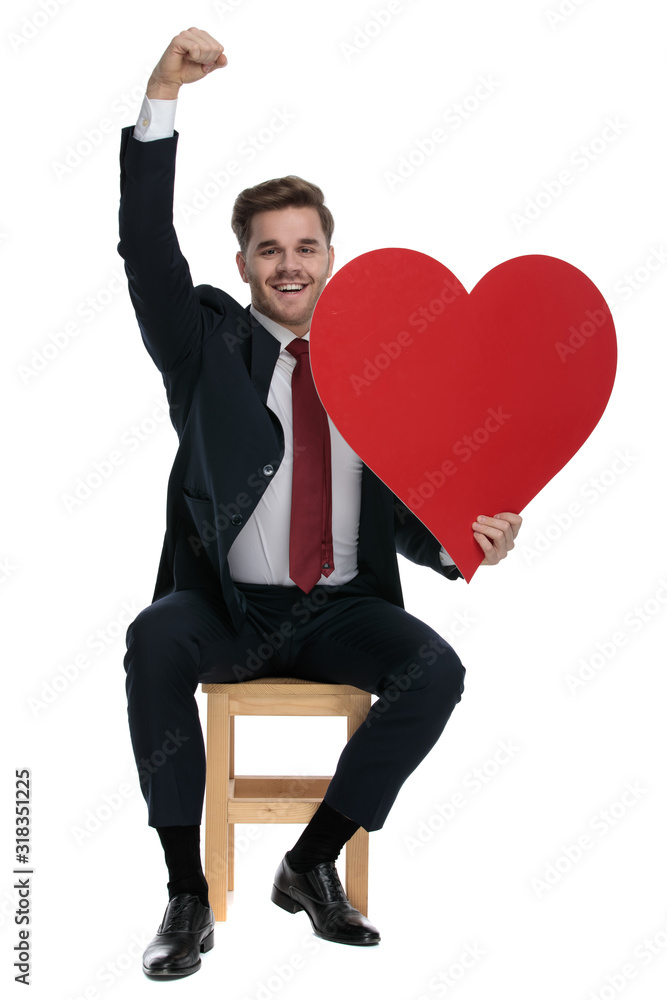 young elegant man holding big red heart and celebrating young elegant man holding big red heart and celebrating